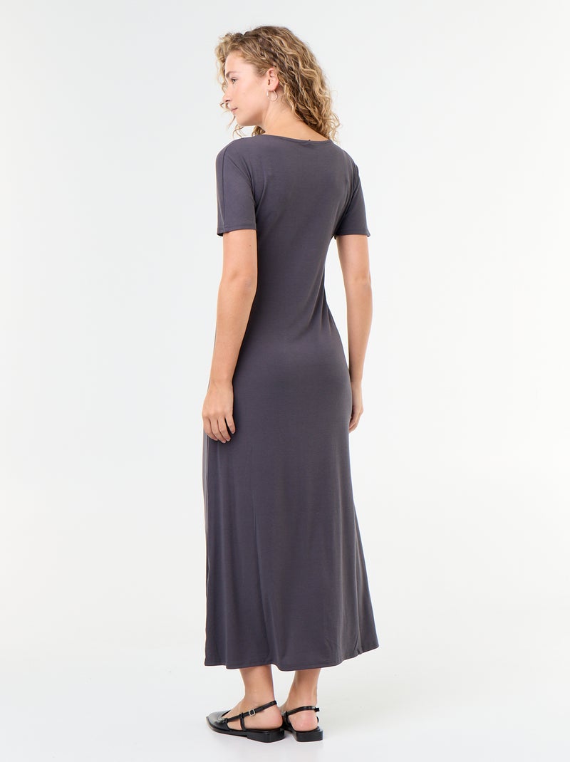 Langes Kleid mit Plisseefalten und gehämmerter Goldbrosche. Grau - Kiabi