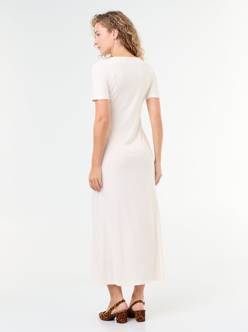 Langes Kleid mit Plisseefalten und gehämmerter Goldbrosche. Weiß - Kiabi