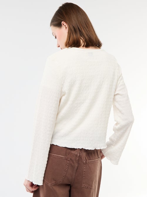 Top a collo a V in maglia goffrata con bottoni dorati - Kiabi Top a collo a V in maglia goffrata con bottoni dorati - Kiabi