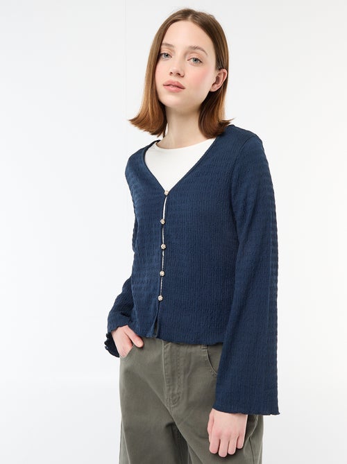 Top a collo a V in maglia goffrata con bottoni dorati - Kiabi Top a collo a V in maglia goffrata con bottoni dorati - Kiabi