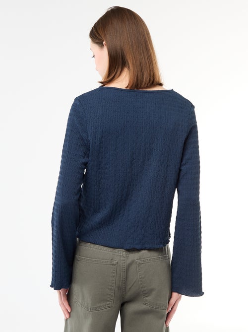 Top a collo a V in maglia goffrata con bottoni dorati - Kiabi Top a collo a V in maglia goffrata con bottoni dorati - Kiabi